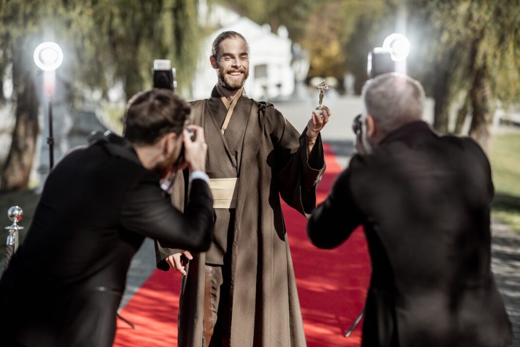 Film actor with photographers on the red carpet outdoors